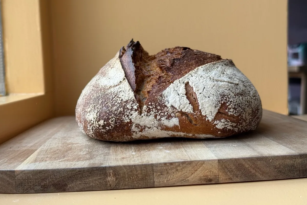 Een vers gebakken brood tegen een warme muur.